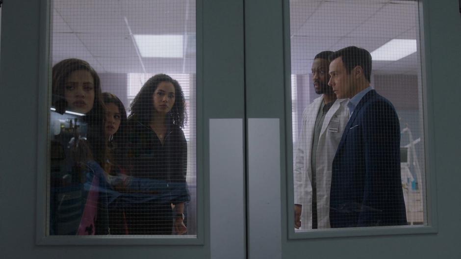 Maggie, Mel, and Macy look into the quarantine ward while Galvin explains the outbreak to them and Harry.