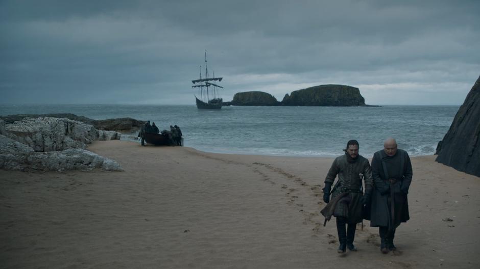 Varys talks to Jon about the queen while they walk up the beach.