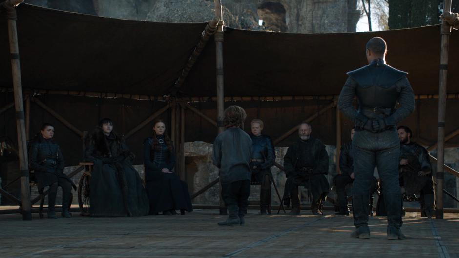 Arya, Bran, Sansa, Brienne, Davos, and the others watch Tyrion as he talks.