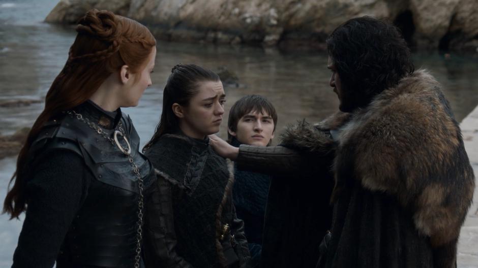 Sansa and Bran watch as Jon puts his hand on Arya's should while saying goodbye.