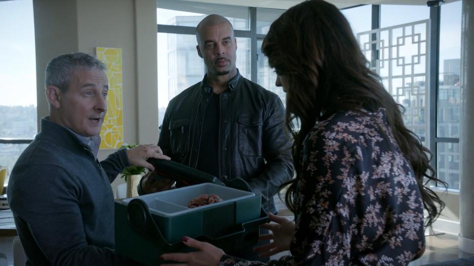 Stacey Boss hands the lid of the cooler to his associate while presenting Al Bronson with a fancy brain.