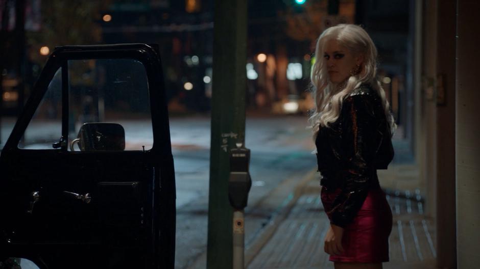 The female zombie involved in the kidnapping looks around before getting into the car.