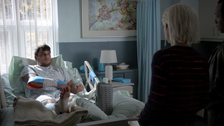 Darren Caulley explains his alibi to Liv and Clive while handcuffed to the hospital bed.