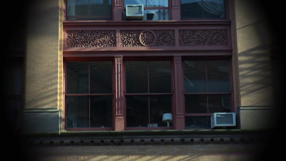 Jessica looks at the building across the street through Trish's binoculars.