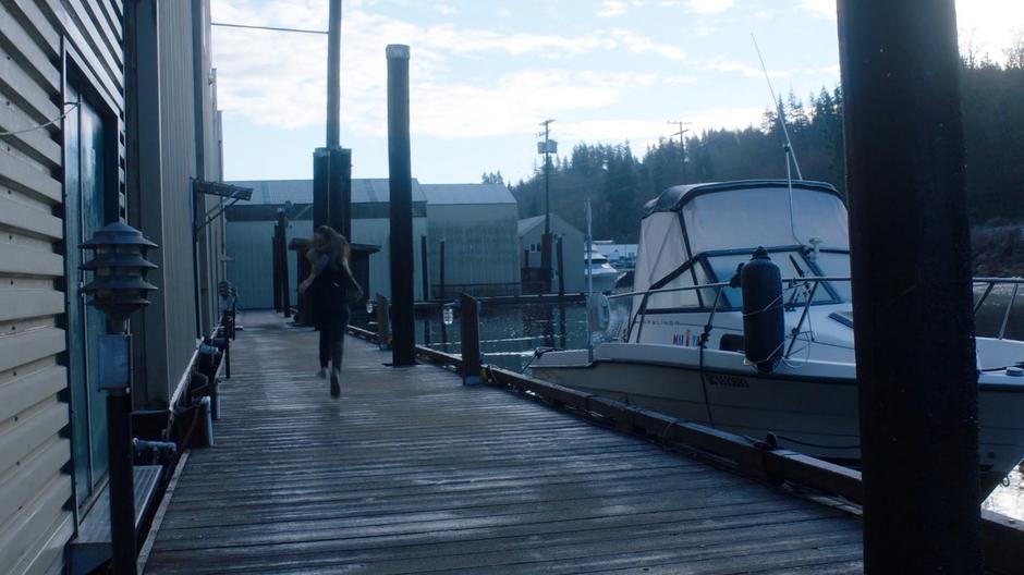 Ryn runs down the dock after escaping the tank.