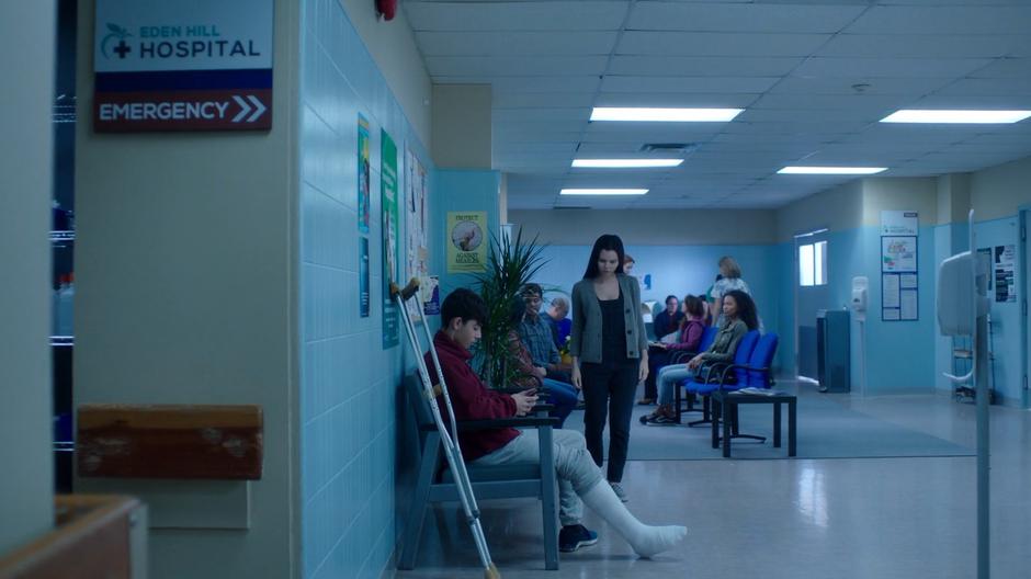 Maddie sits in the waiting area while Ryn wanders around looking at hospital stuff.