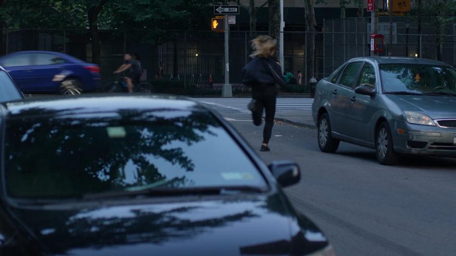 Trish runs across the street after the cellphone thief.