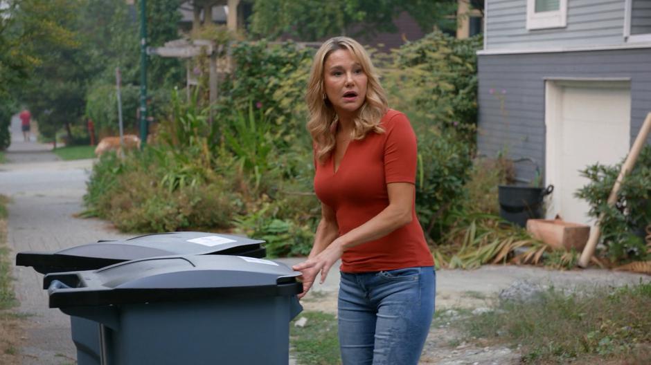 Mrs. Jones turns from her trash cans when she sees Liv and Clive approaching.