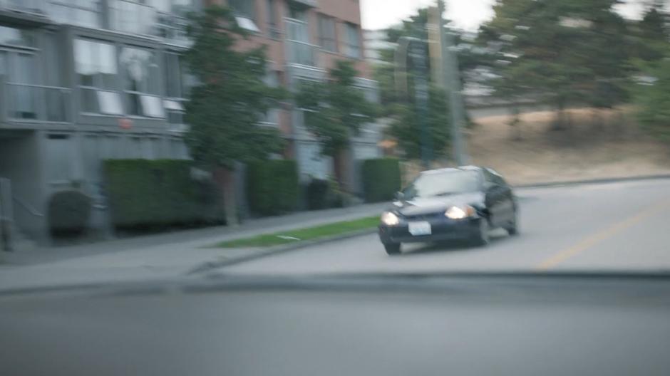 A car speeds past down the street.