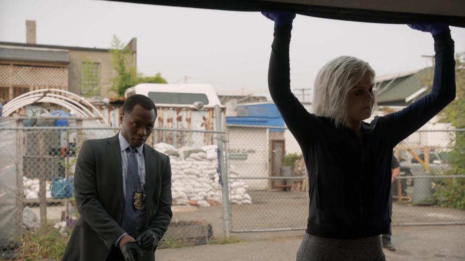 Clive puts on his gloves while Liv opens the garage door.