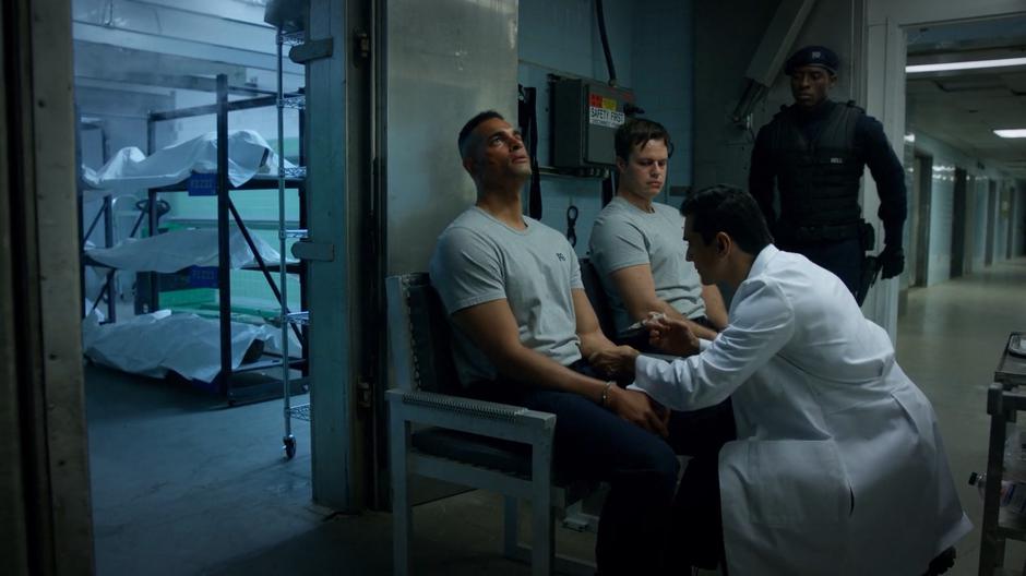 The two soldiers responsible for the attack are prepared for freezing by a doctor while Justin stands guard.