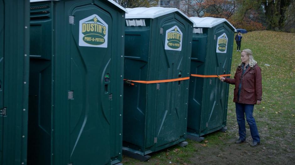 Dolly Durkins slides the ratchet straps holding the two port-a-potties containing the feral zombies shut.