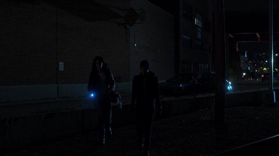 Trish tells Jessica to turn off her flashlight while they walk towards the gate.