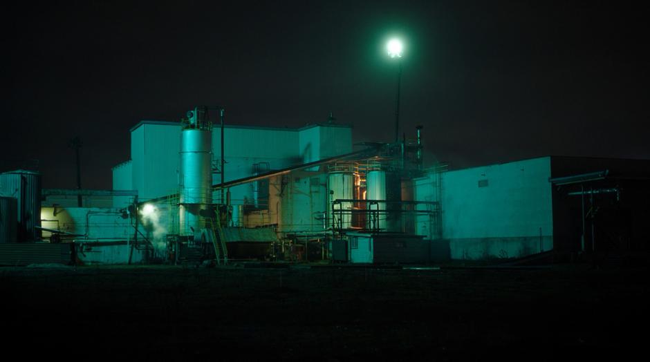 Establishing shot of the factory sitting in the dark.