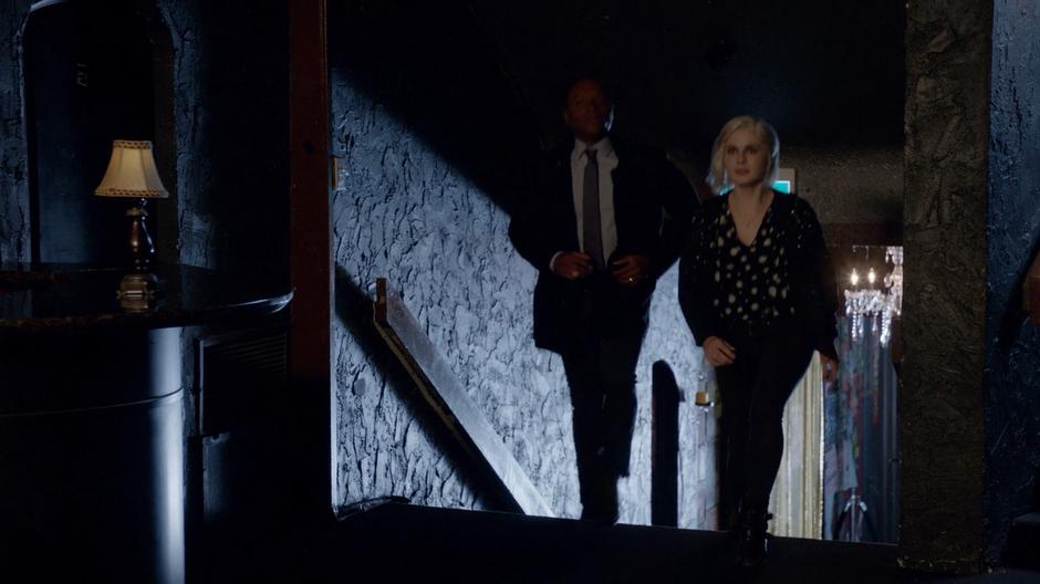 Clive and Liv walk up the stairs into the main room.