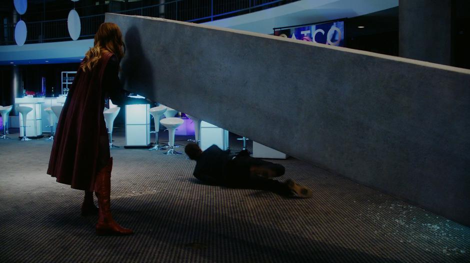 Kara stops a falling pillar from crushing a gala attendee.