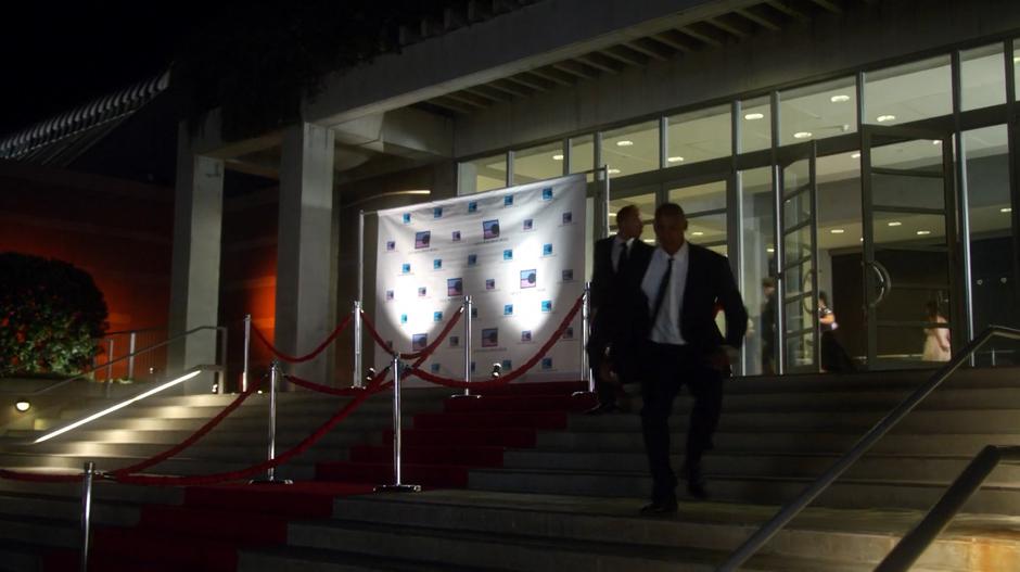 James flees the building past the red carpet.