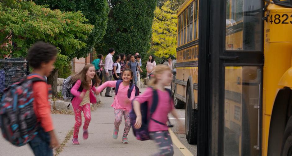 Kids excitedly run to the school bus.