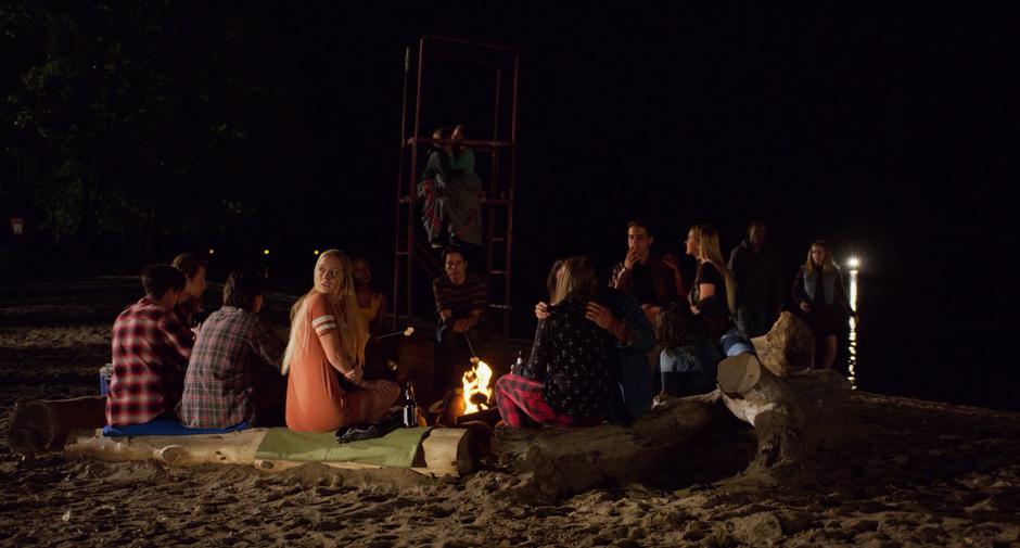 Hope turns around from the party of kids around the campfire when she hears a car speeding down the beach.