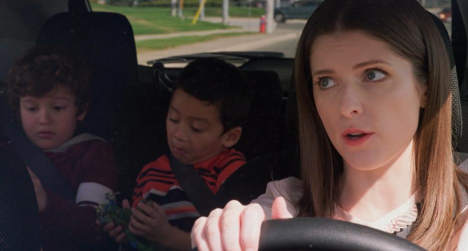 Stephanie tells Miles and Nicky to put away their dolls as she drives them across town.