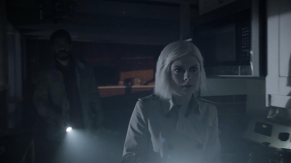 Ravi and Liv sneak through the house at night illuminated by their flashlights.