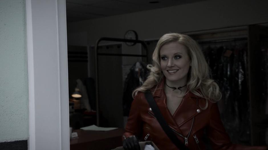 Candy smiles as she walks out of the dry cleaners with the coat.