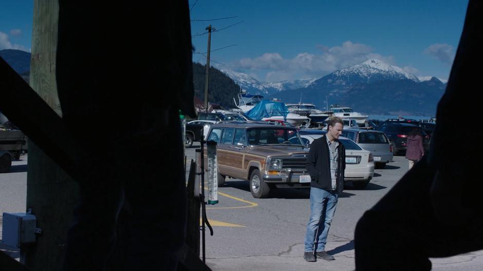 Chris stands paused in the parking lot lost in his traumatic memories.