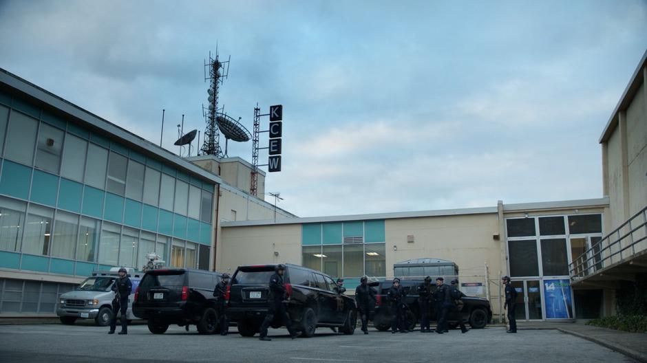 Fillmore Graves mercenaries exit their vehicles to escort Enzo Lambert inside the studio.