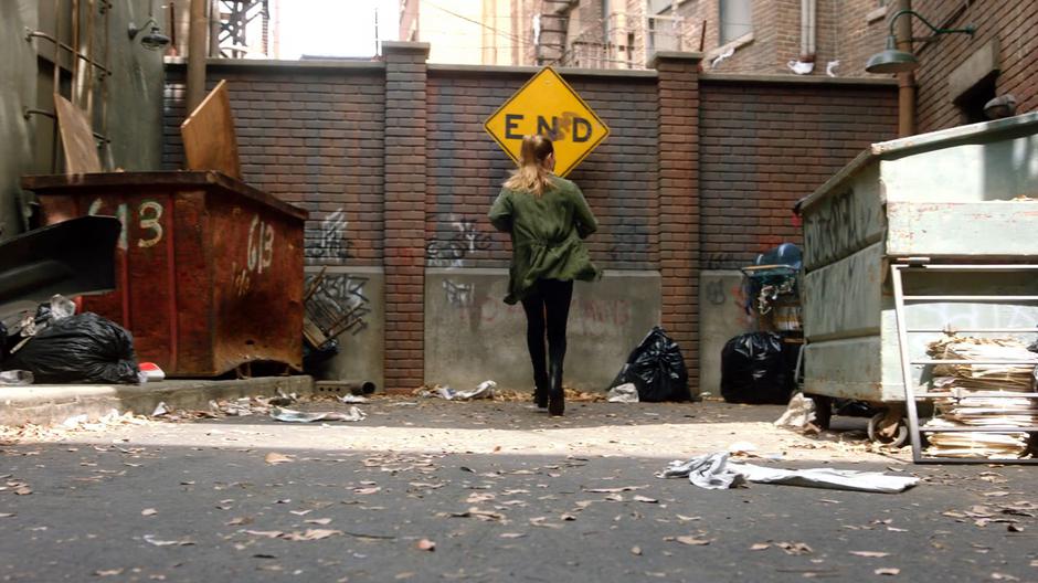 Chloe comes to a stop when she finds the alley blocked in a dead end.