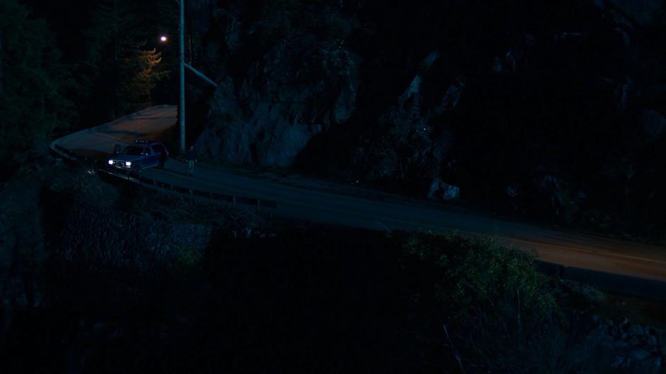 Ben walks down the road after blocking the path with his truck.