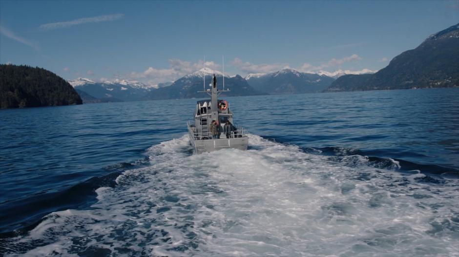 Calvin and Xander stand on the back fo the boat as it heads back to shore.