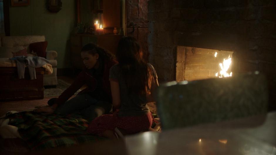 Maddie sits with Ryn in front of the fire and talks to her.