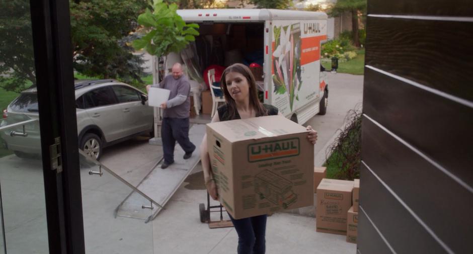 Stephanie carries a box of her things in from her U-Haul.