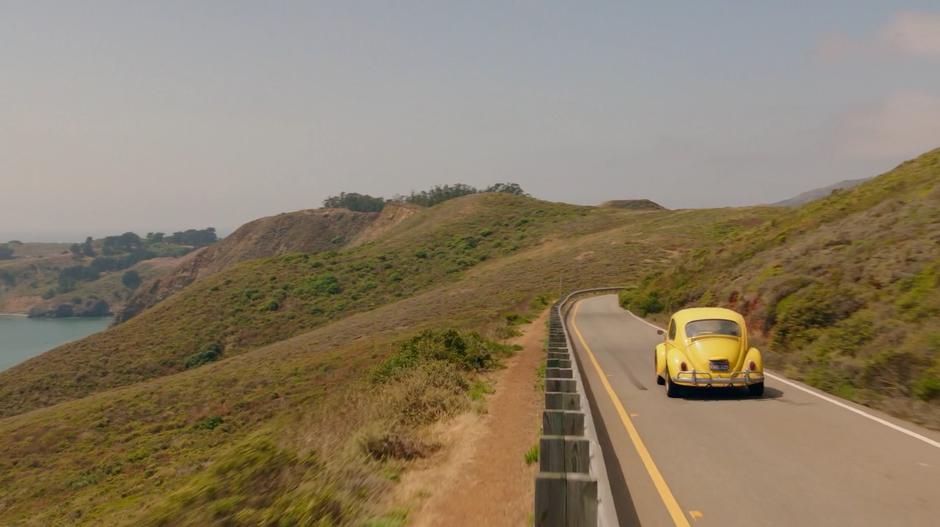 Bumblebee drives down the road along the coast.
