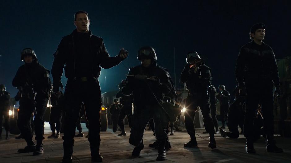 Agents Burns stands outside the closed lab with his soldiers while holding a detonator.