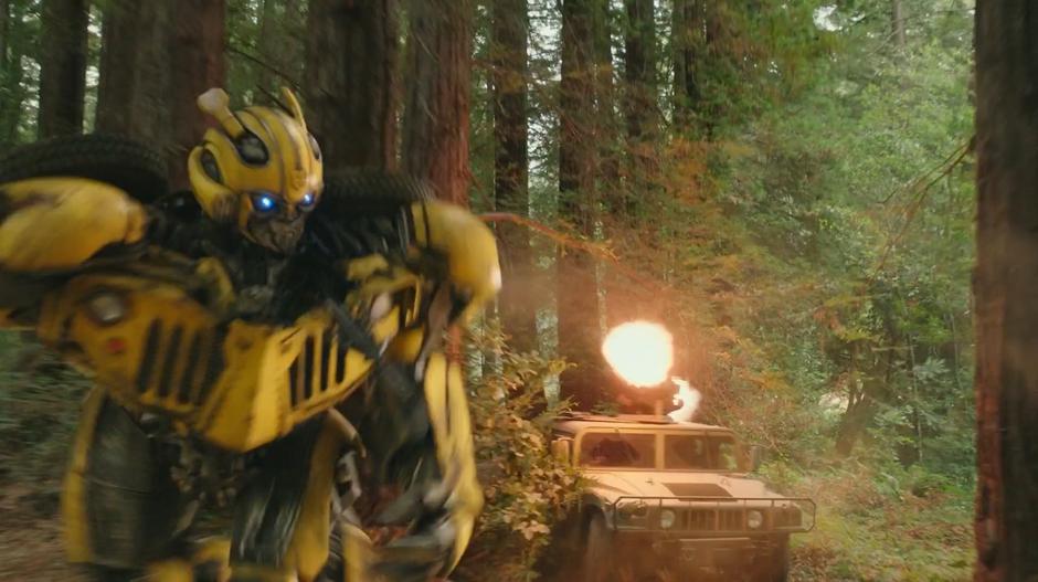 Bumblebee runs through the forest as a Humvee fires at him.