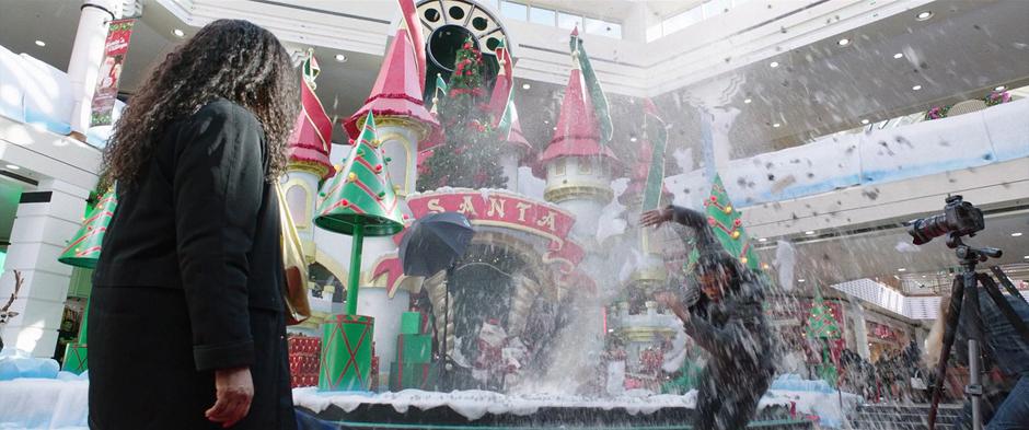 A spray of fake snow from Santa's Village explodes into the air when Billy is thrown through the ceiling.
