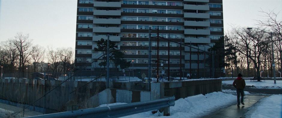 Billy walks down the sidewalk towards his mother's apartment building.