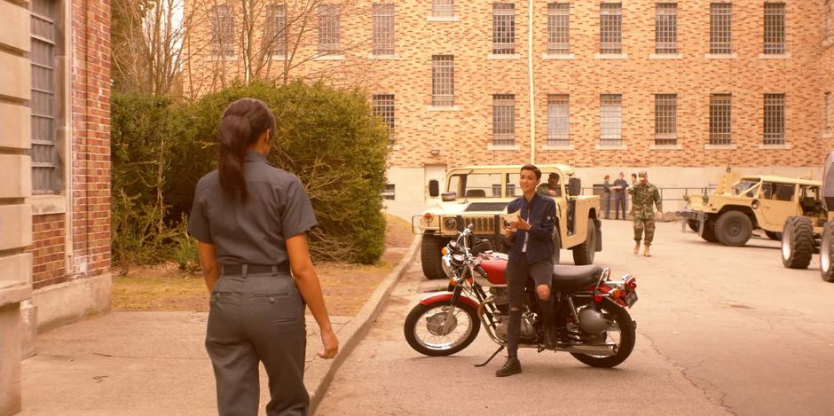 Kate leans against her bike and crumples up the denial letter after reading it to Sophie.