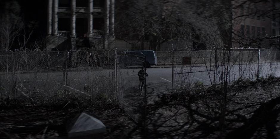 Kate runs through the fence surrounding the building past the van that was used to kidnap Sophie.