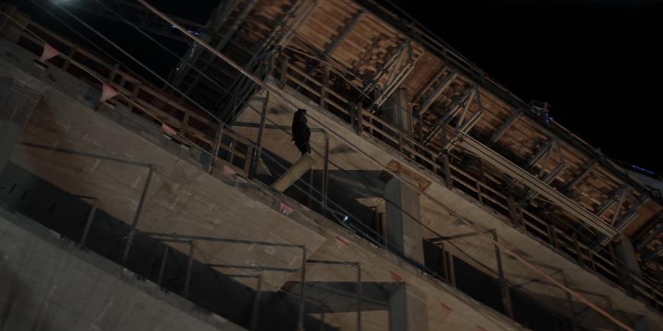 Sophie stand on a plank out over the edge of the construction site.