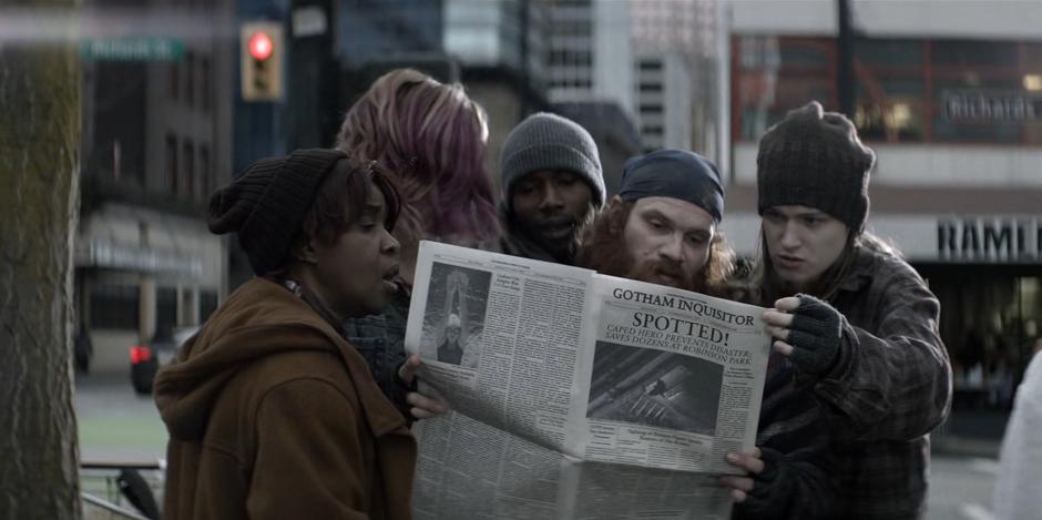 A group of people read a newspaper article about Kate's rescue the night before.