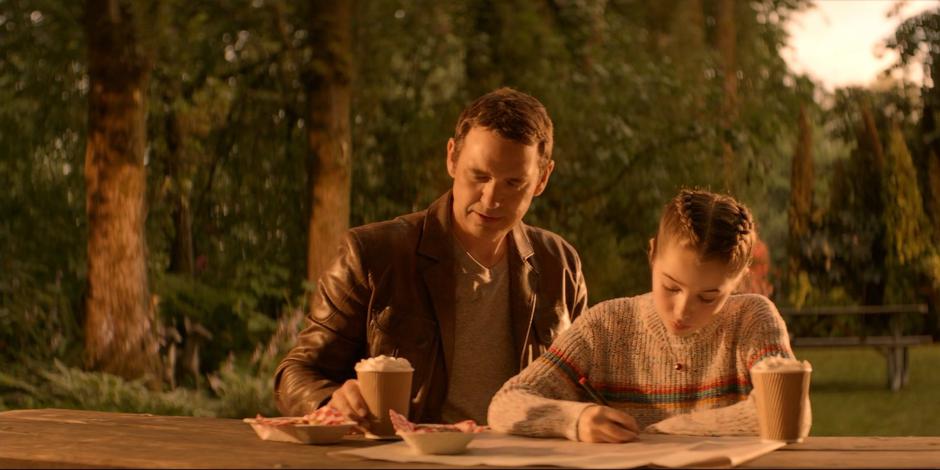 When Kate was younger, Jacob sits down with her and offers her a snack while she is working on her search map.