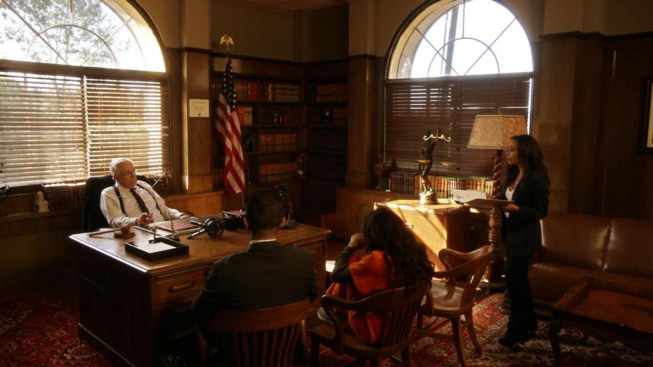 Cecile stands and talks to the judge about the plea while Allegra and her lawyer sit in chairs.