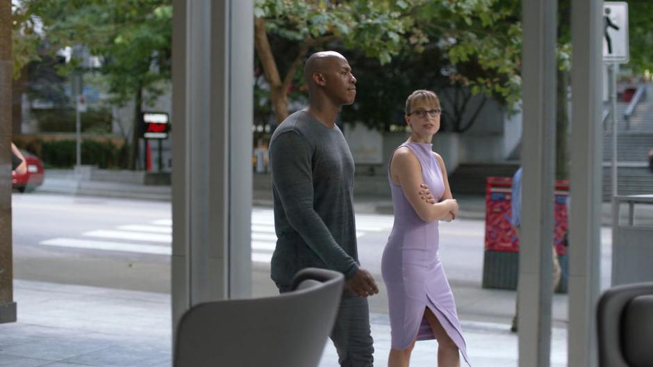 Kara talks to James about the death as they walk down the sidewalk in front of the building.