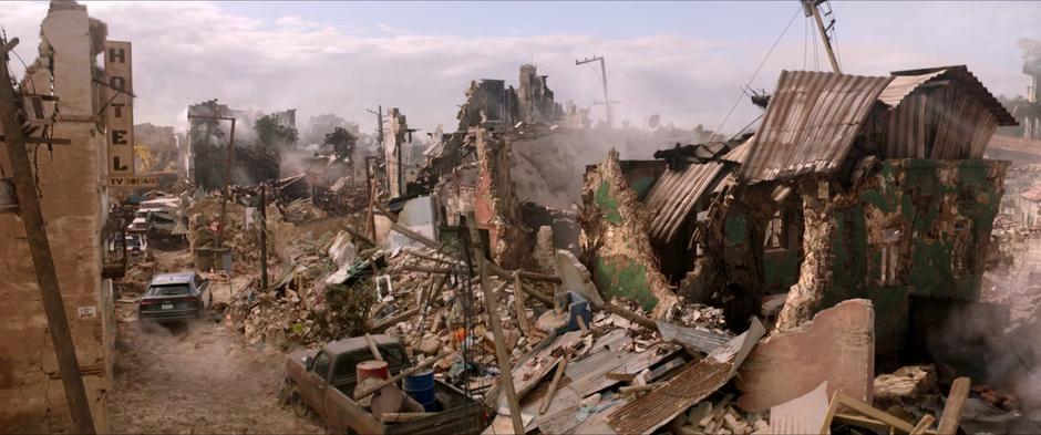Hill and Fury's car drives through the rubble of the ruined town.