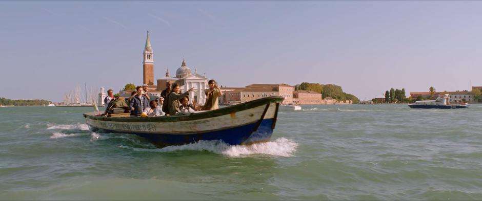 Michelle points ahead while the other members of the group look at the approaching city of Venice.