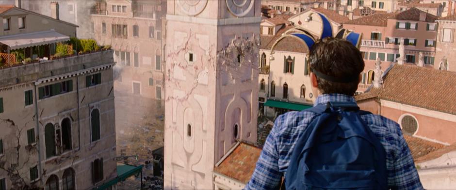 Peter stands on a rooftop overlooking the square and sees the tower start to crack.