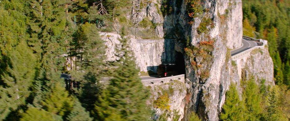The tour bus drives through a rock arch that the cliffside road was constructed through.