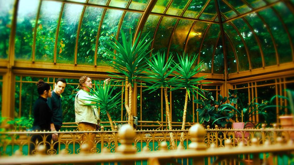 Mel and Harry share a look while the Sentinel examines one of his plants in the greenhouse.